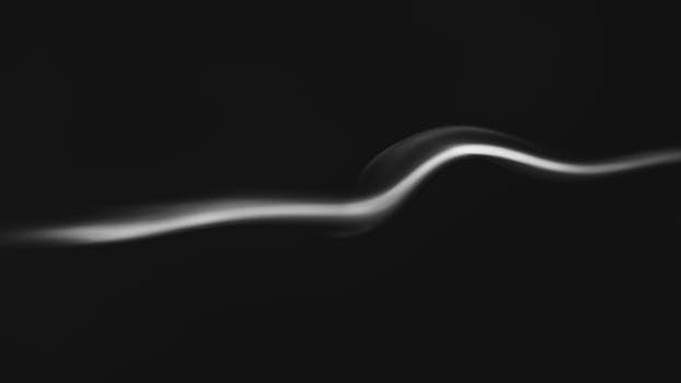 Artistic black and white photo of a smooth smoke curve on a dark background.